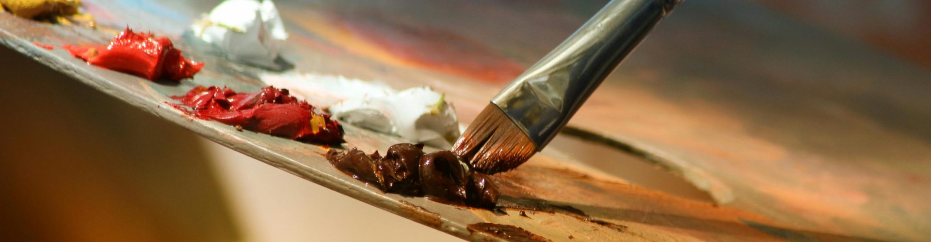 Vibrant artist palette with paint and brush creating colorful artwork.