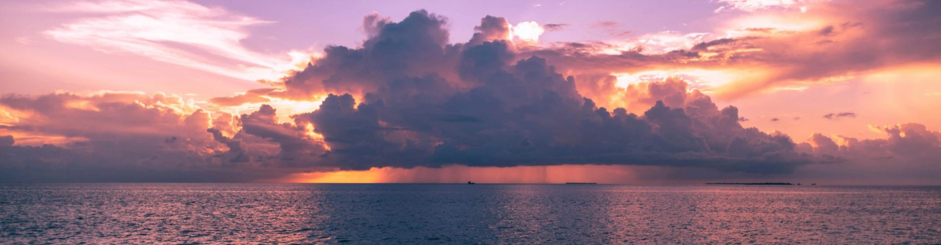 Stunning sunset view with dramatic clouds over the ocean in Maldives, perfect for travel inspiration.