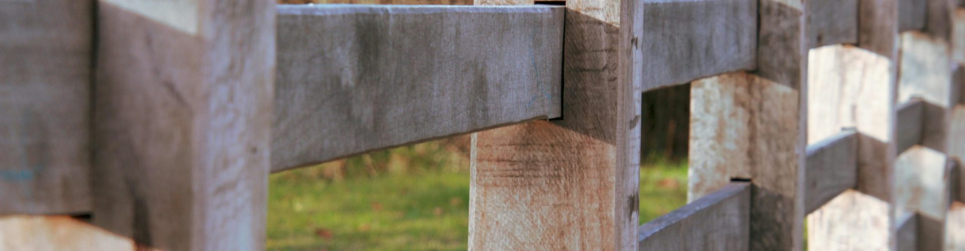 Detailed shot of a wooden fence with a natural background, capturing texture and depth.