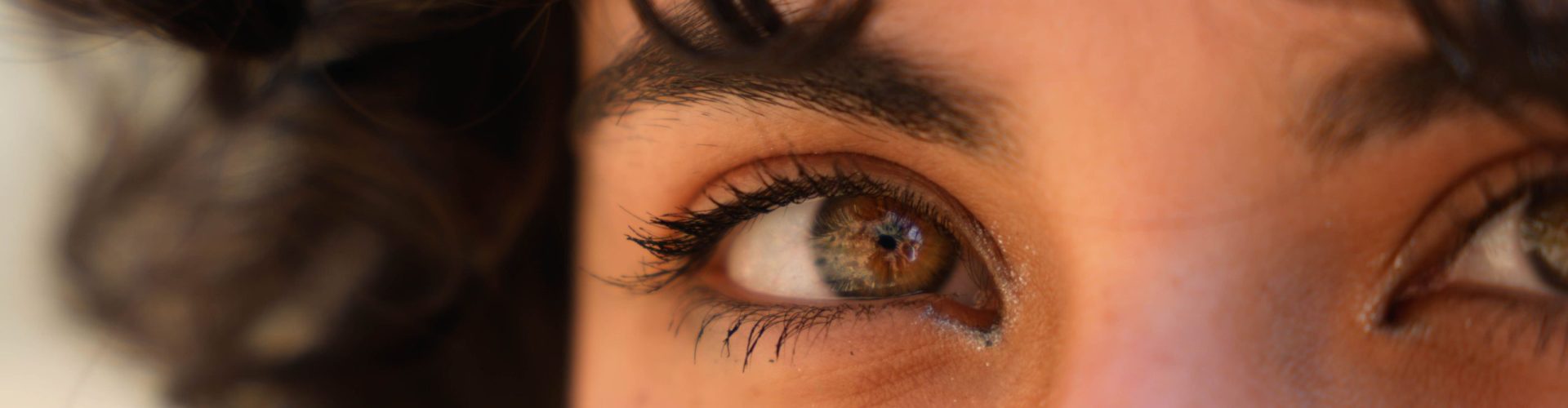 An artistic close-up image capturing the vivid detail and natural beauty of eyes with reflective light.