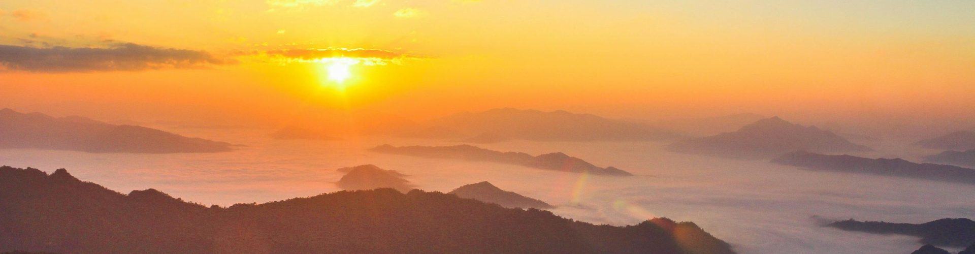 Stunning sunrise scene with mist-covered valleys and majestic mountain landscape.